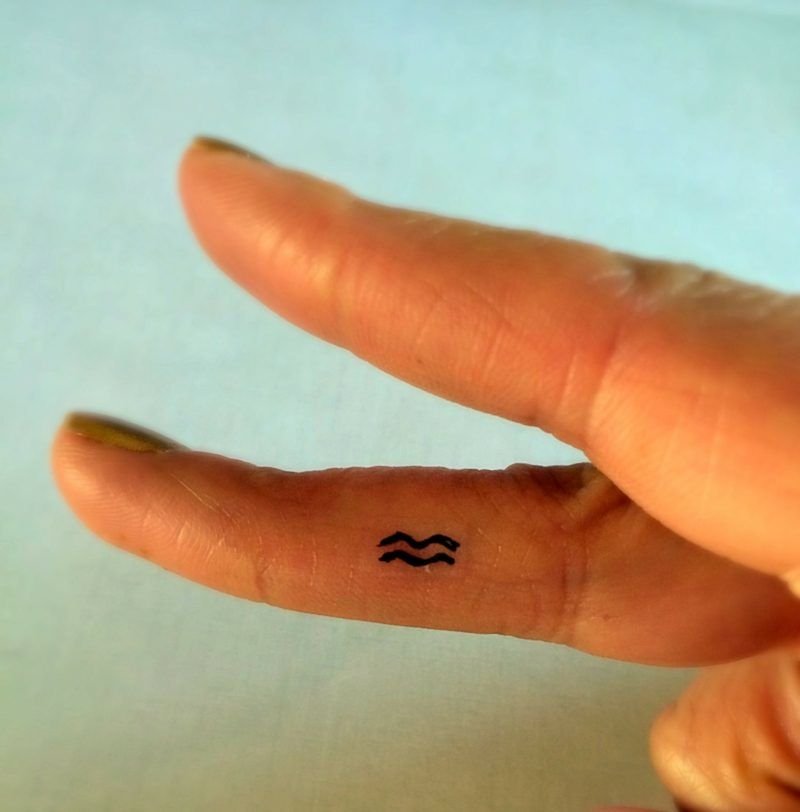 Aquarius Script Finger Tattoo